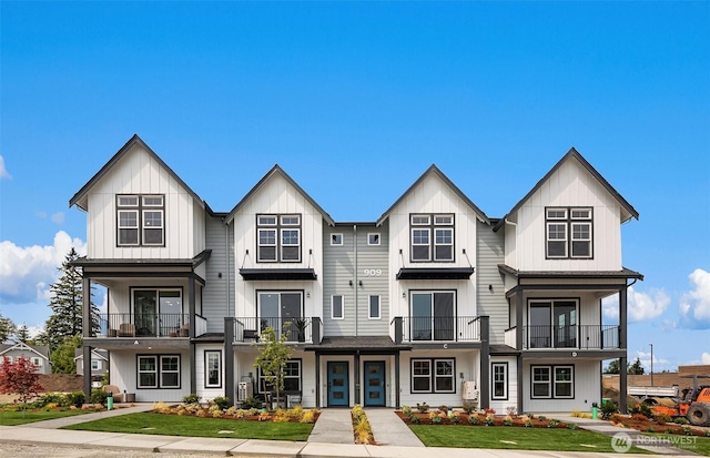 townhome / multi-family property featuring a front lawn and board and batten siding