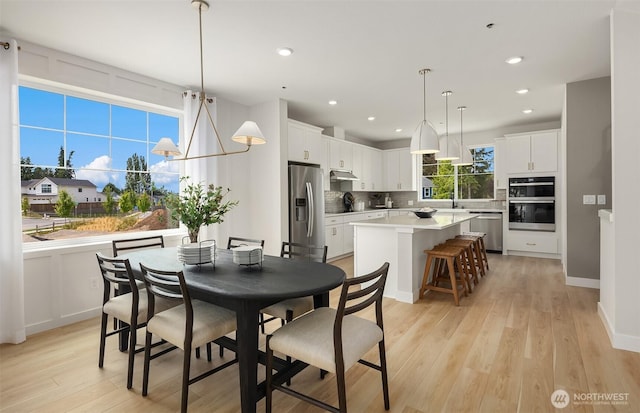 dining area with light wood finished floors, baseboards, and recessed lighting