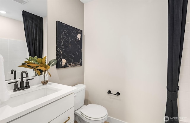 bathroom with toilet, baseboards, vanity, and visible vents