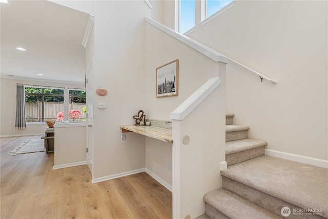 stairway featuring wood finished floors, baseboards, and recessed lighting