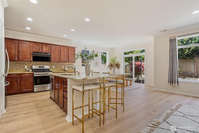 kitchen featuring stainless steel gas range, light wood-type flooring, plenty of natural light, backsplash, and recessed lighting