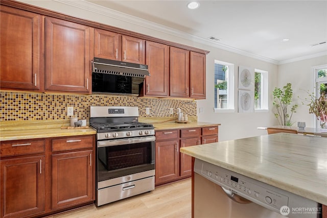 kitchen with stainless steel appliances, decorative backsplash, light wood-style floors, ornamental molding, and recessed lighting