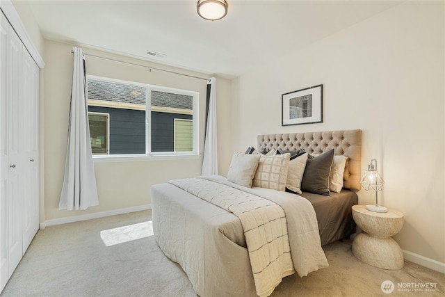 bedroom with light carpet, baseboards, and a closet