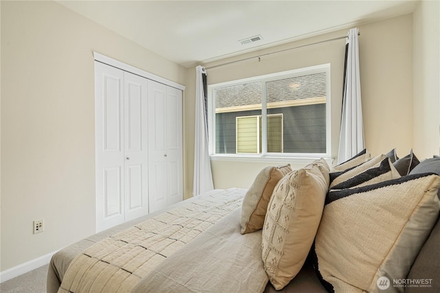 carpeted bedroom featuring a closet and baseboards
