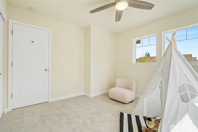 sitting room featuring carpet, ceiling fan, and baseboards