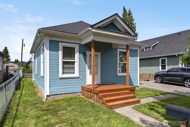 shotgun-style home featuring roof with shingles