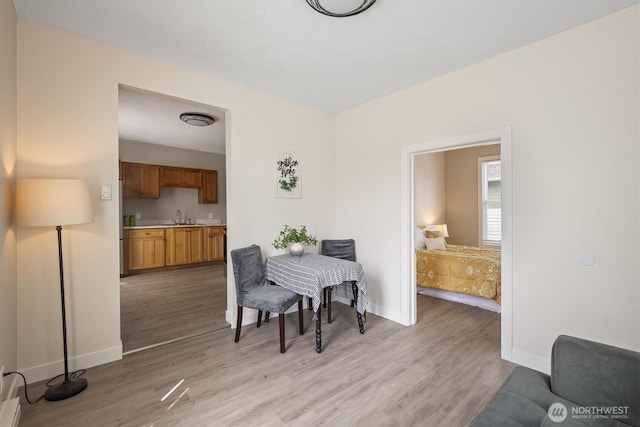 dining room featuring baseboards and light wood-style floors