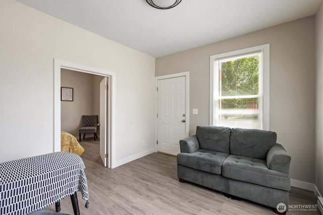 living area featuring light wood-style flooring and baseboards
