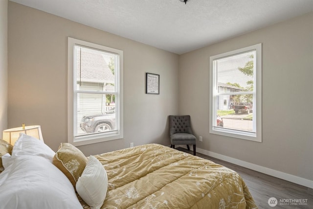 bedroom featuring wood finished floors and baseboards
