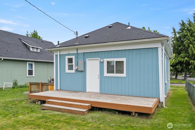 back of house featuring a wooden deck and roof with shingles