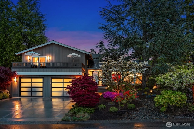 view of front of house featuring driveway, a balcony, and a garage