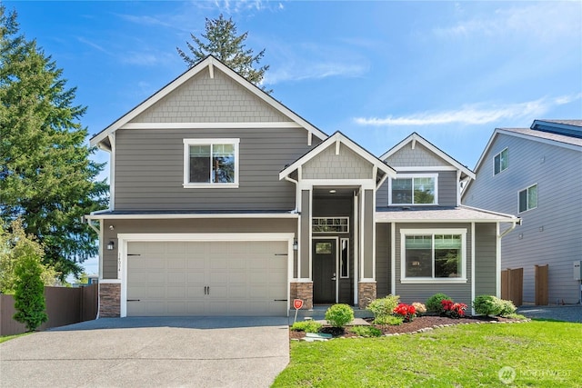 craftsman-style house with an attached garage, stone siding, and driveway