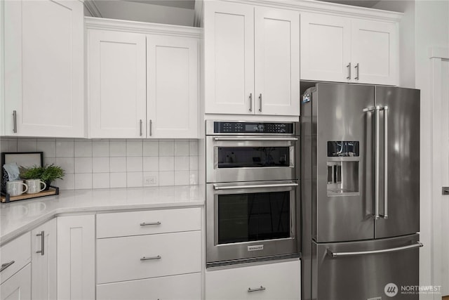 kitchen with appliances with stainless steel finishes, light countertops, and white cabinetry