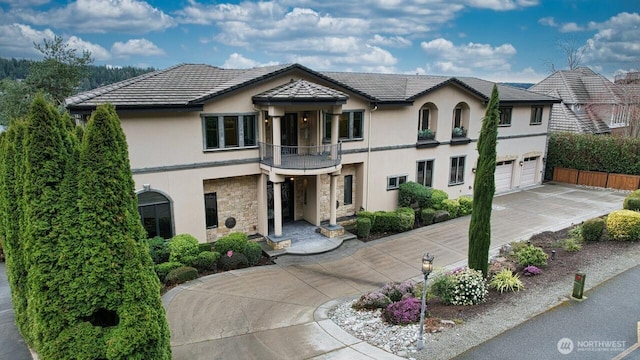 2837 E Lake Sammamish Pkwy NE, Sammamish, WA 98074 - view of front facade with a balcony, concrete driveway, stucco siding, stone siding, and a garage