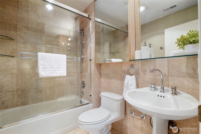 707 Harvest Rd, Bothell, WA 98012 - full bath featuring tile walls, bath / shower combo with glass door, toilet, and a sink