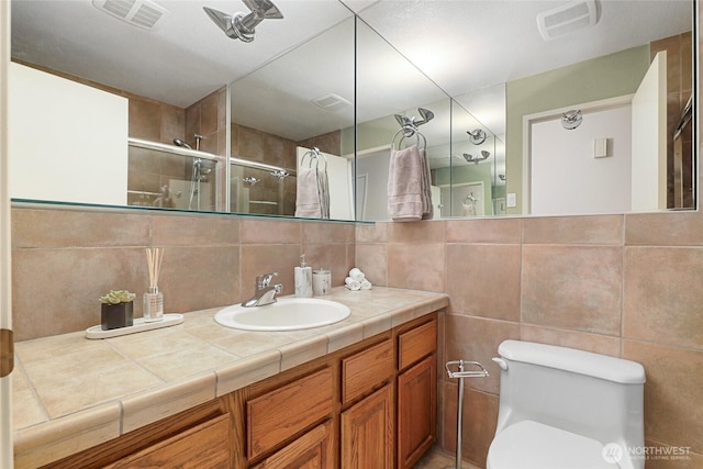 707 Harvest Rd, Bothell, WA 98012 - bathroom with a stall shower, toilet, vanity, backsplash, and tile walls