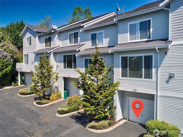 14721 1st Ln NE Unit 102, Duvall, WA 98019 - view of property with an attached garage, asphalt driveway, and a shingled roof