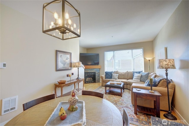 14721 1st Ln NE Unit 102, Duvall, WA 98019 - dining room featuring a fireplace, a chandelier, baseboards, and wood finished floors