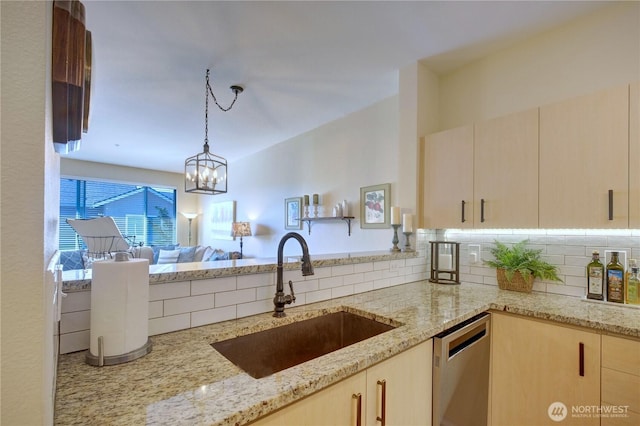 14721 1st Ln NE Unit 102, Duvall, WA 98019 - kitchen with stainless steel dishwasher, a sink, decorative backsplash, light stone countertops, and decorative light fixtures