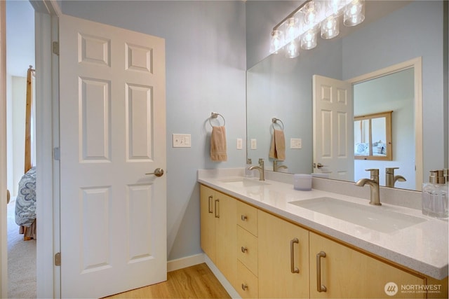 14721 1st Ln NE Unit 102, Duvall, WA 98019 - bathroom featuring double vanity, baseboards, and wood finished floors