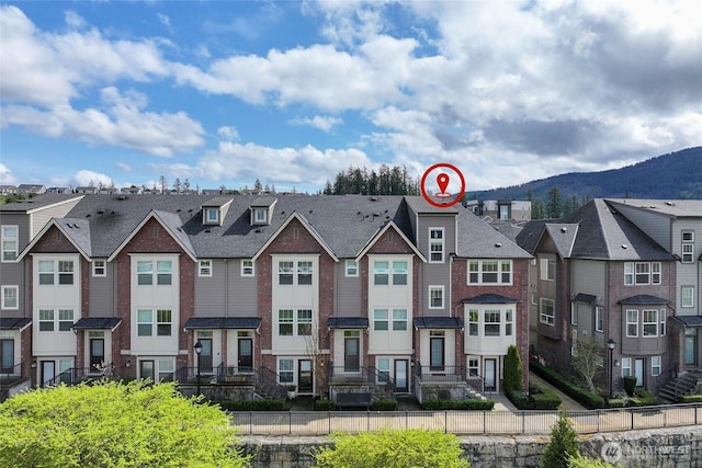 view of property featuring a mountain view, a residential view, and fence private yard