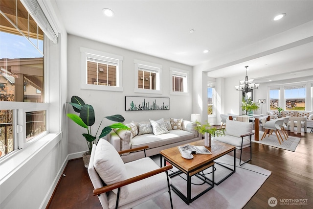 living room featuring a chandelier, wood finished floors, baseboards, and recessed lighting