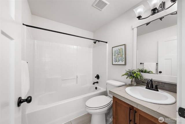 bathroom featuring toilet, visible vents, vanity, and shower / bathtub combination