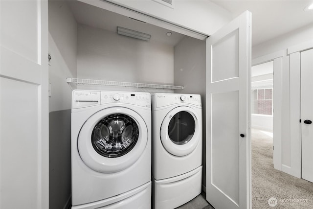 clothes washing area with laundry area, washing machine and dryer, and carpet floors