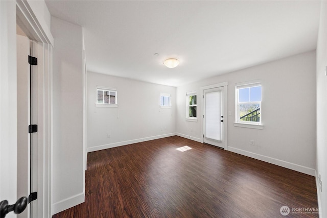 foyer with dark wood-style flooring and baseboards