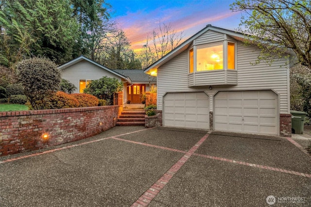 view of front of property featuring an attached garage, brick siding, and driveway