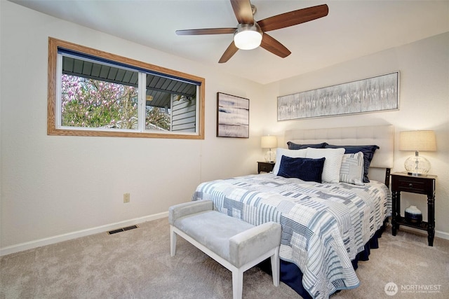 carpeted bedroom with baseboards, a ceiling fan, and visible vents