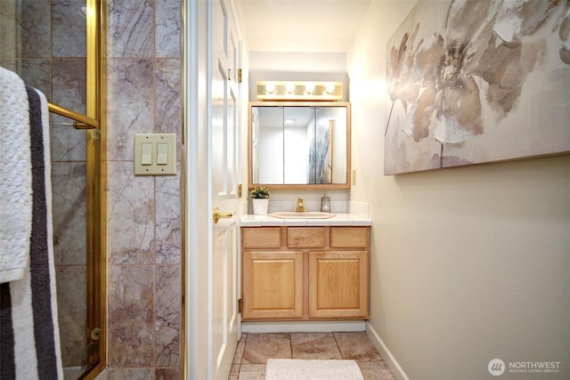 full bath with a shower stall, baseboards, and vanity