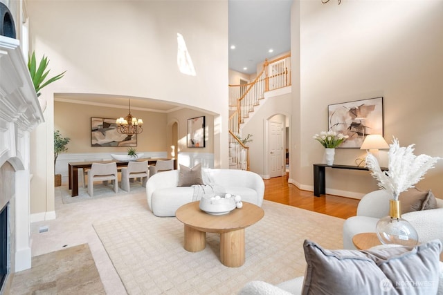 11758 175th Pl NE, Redmond, WA 98052 - living area featuring arched walkways, a fireplace, a high ceiling, stairs, and a chandelier