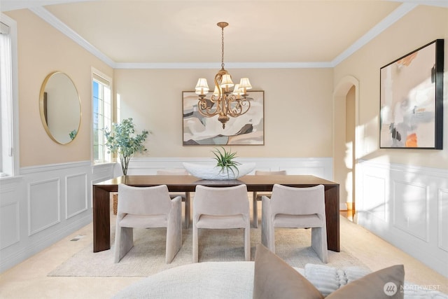 11758 175th Pl NE, Redmond, WA 98052 - carpeted dining area with a chandelier, ornamental molding, a wainscoted wall, a decorative wall, and arched walkways