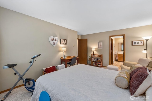 bedroom with light colored carpet and ensuite bathroom