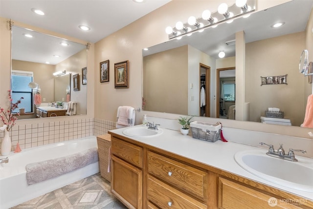 full bathroom featuring a bath, double vanity, and recessed lighting