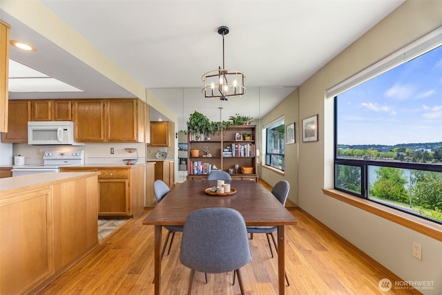 dining area featuring light wood-style flooring and a chandelier