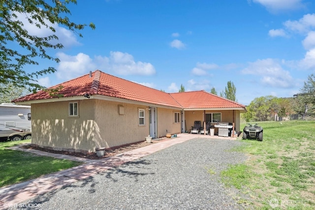 21058 State Highway 17 N, Soap Lake, WA 98851 - back of house featuring a tiled roof, a lawn, and a patio