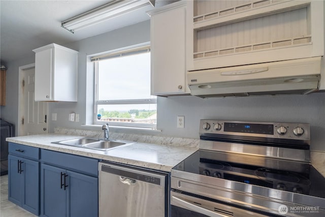 kitchen featuring stainless steel appliances, blue cabinetry, a sink, light countertops, and under cabinet range hood