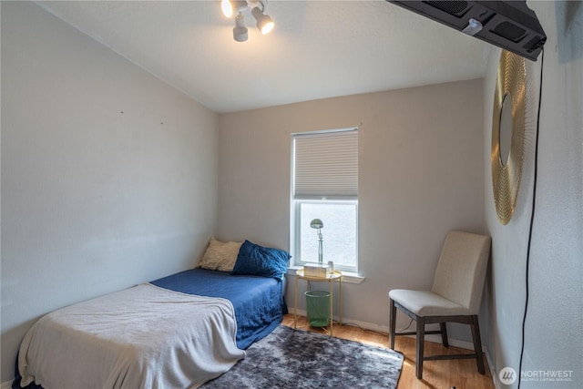 bedroom with wood finished floors and baseboards