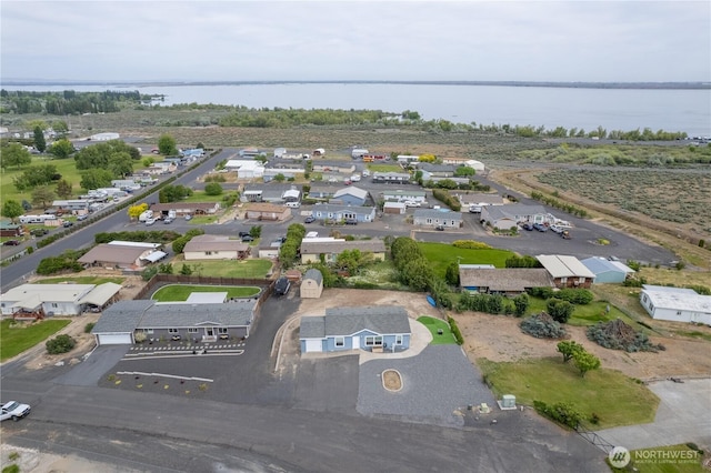 aerial view of property's location featuring a nearby body of water and nearby suburban area