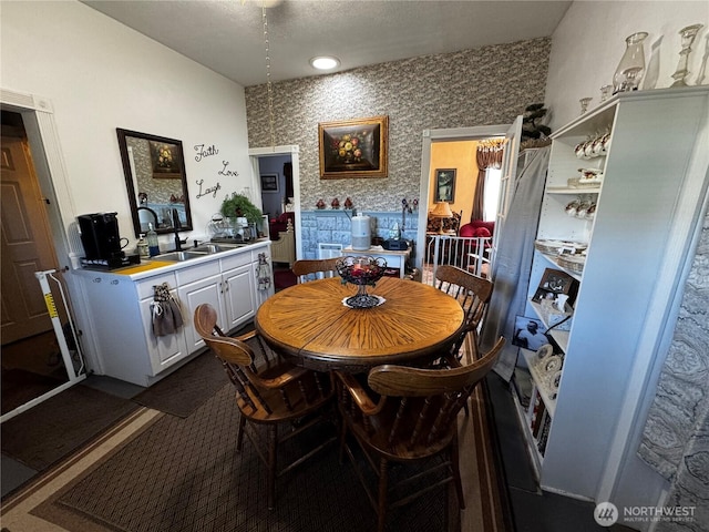 dining area featuring wallpapered walls