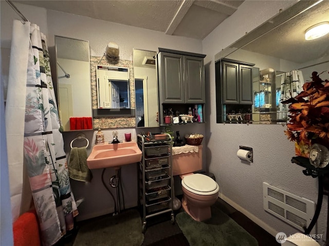 bathroom featuring a sink, toilet, a shower with curtain, and heating unit