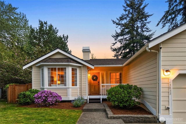 view of front of home featuring fence and a chimney