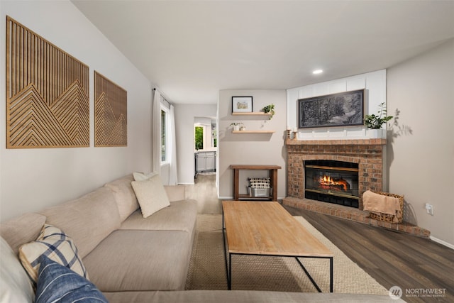 living room featuring wood finished floors, a fireplace, baseboards, and recessed lighting