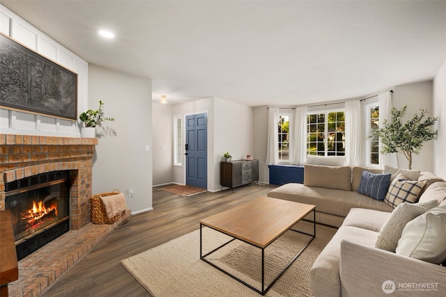 living room with wood finished floors, a fireplace, baseboards, and recessed lighting