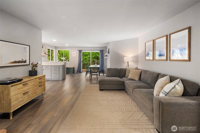 living room with dark wood-type flooring and recessed lighting
