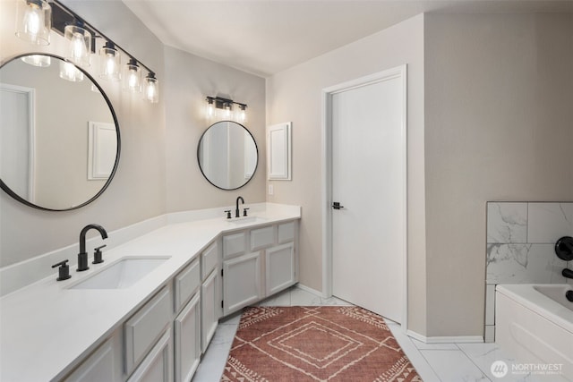 bathroom featuring double vanity, a tub, marble finish flooring, and baseboards