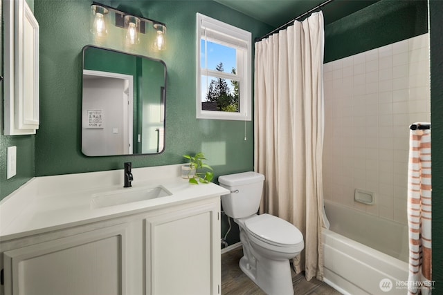 full bathroom with a textured wall, wood finished floors, toilet, vanity, and shower / tub combo