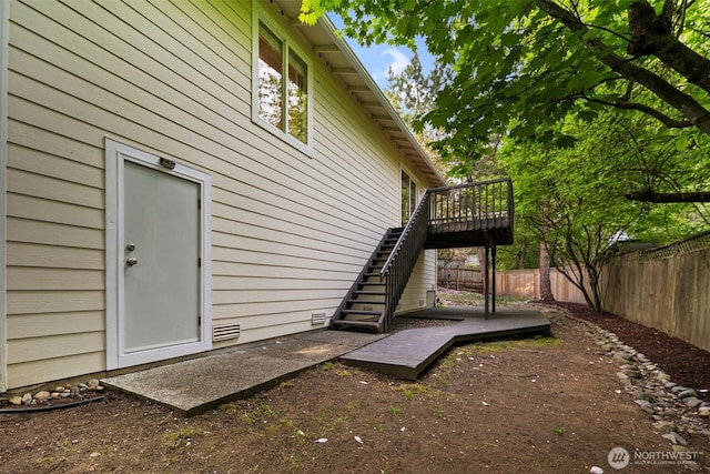view of side of property with a fenced backyard, stairs, and a wooden deck